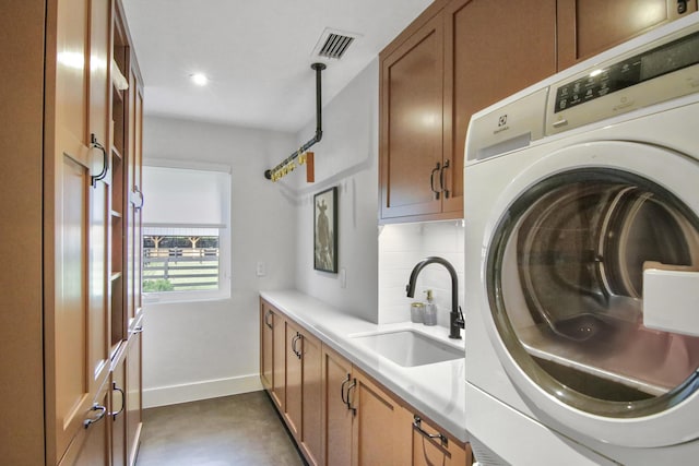 laundry area with washer / clothes dryer, cabinet space, visible vents, a sink, and baseboards