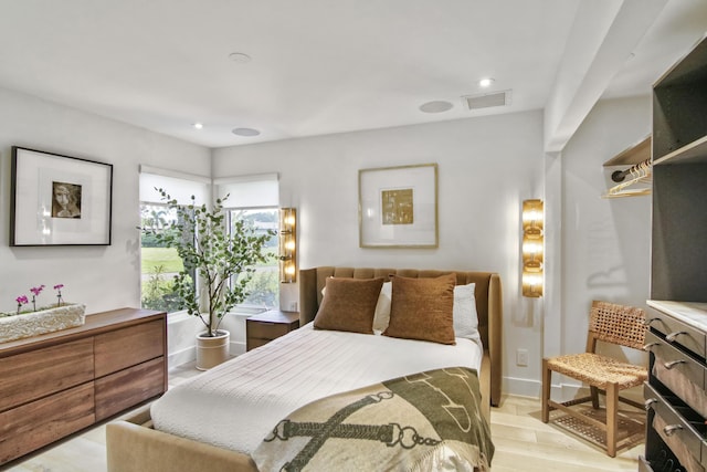 bedroom with light wood-style floors, baseboards, and visible vents