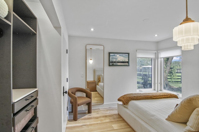 bedroom featuring baseboards, light wood finished floors, and recessed lighting