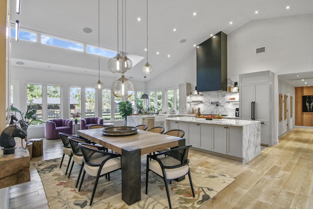 dining space featuring high vaulted ceiling, recessed lighting, visible vents, and light wood finished floors