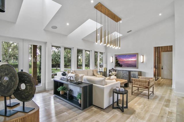 living room featuring light wood-style floors, plenty of natural light, and high vaulted ceiling