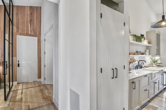 interior space with light wood finished floors, a sink, and decorative light fixtures