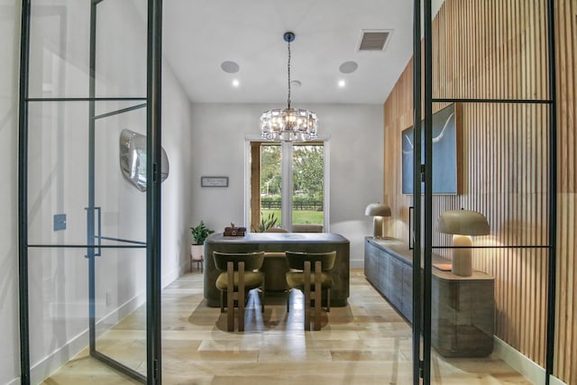 sitting room featuring light wood finished floors, baseboards, visible vents, and a chandelier