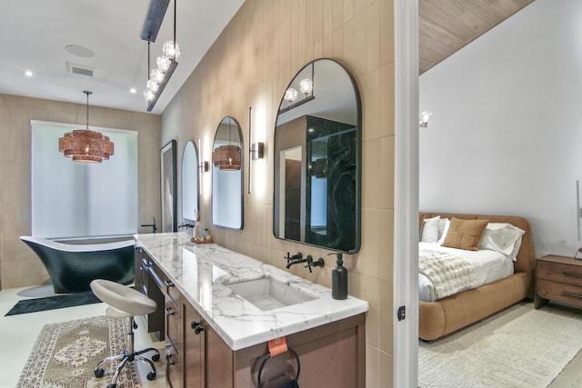 bathroom featuring double vanity, a sink, visible vents, and tile walls