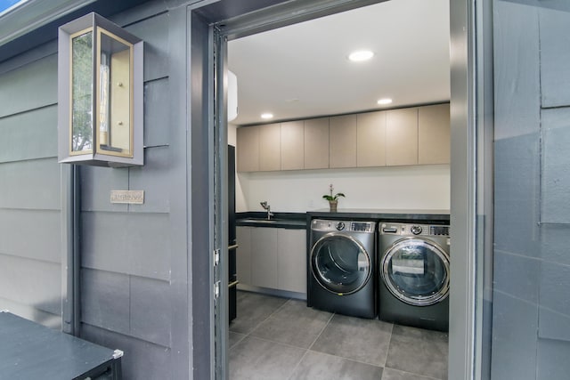 washroom with light tile patterned flooring, recessed lighting, a sink, cabinet space, and washer and clothes dryer