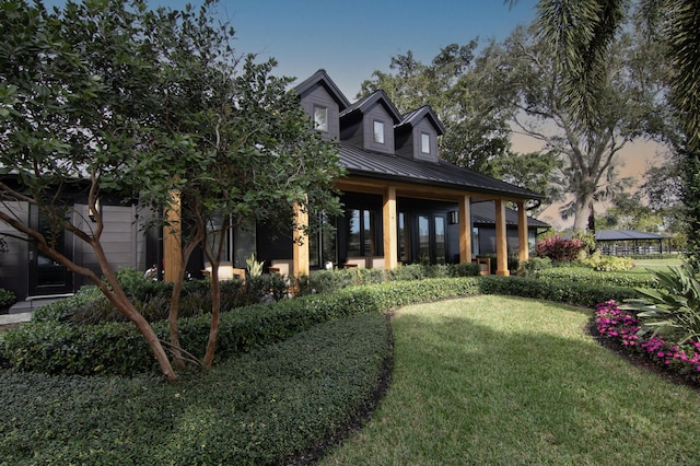 exterior space with metal roof, a standing seam roof, and a front yard