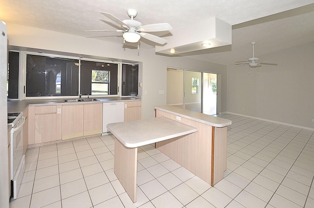 kitchen featuring a kitchen island, light tile patterned floors, light brown cabinetry, and white appliances