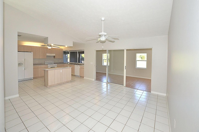 kitchen featuring light tile patterned flooring, vaulted ceiling, light brown cabinets, ceiling fan, and white appliances