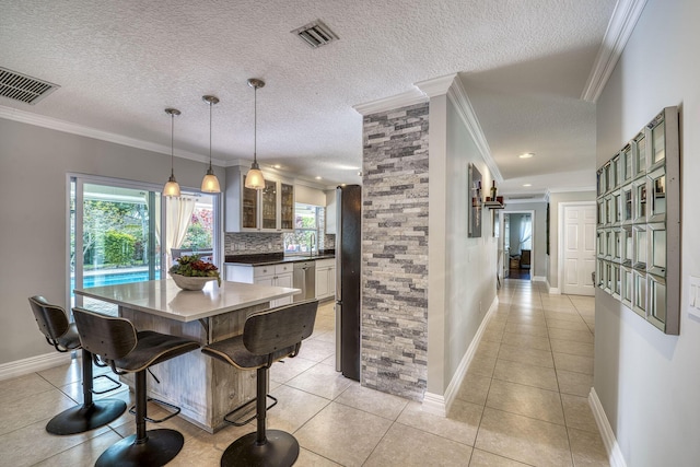 dining area featuring ornamental molding and light tile patterned flooring