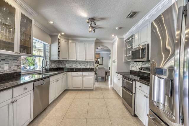 kitchen featuring sink, appliances with stainless steel finishes, white cabinets, and light tile patterned floors