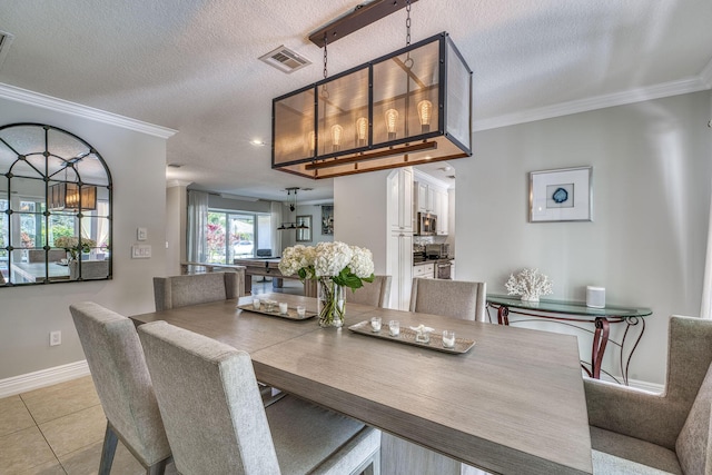 dining room featuring a textured ceiling, crown molding, and light tile patterned floors