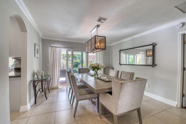 tiled dining room with a textured ceiling and ornamental molding