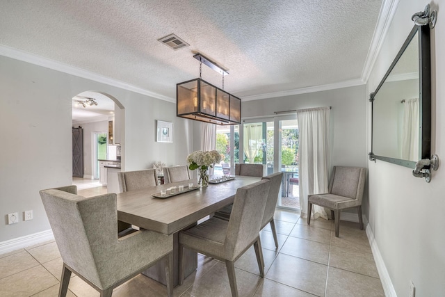 tiled dining room featuring a textured ceiling and ornamental molding