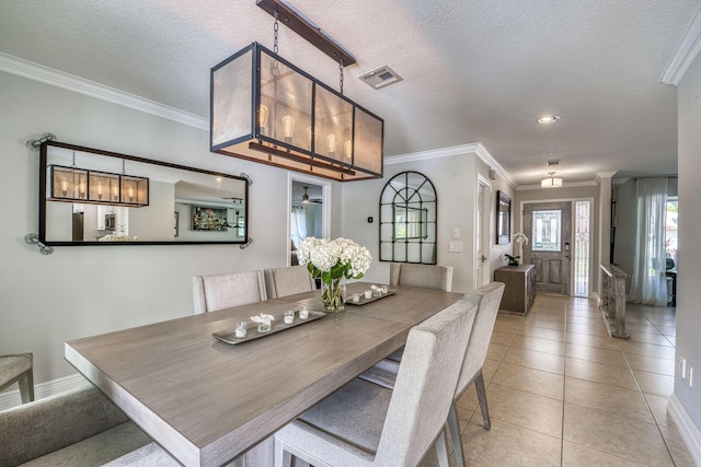 tiled dining area featuring crown molding and a textured ceiling