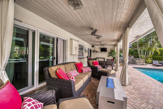 view of patio with ceiling fan and an outdoor living space with a fire pit