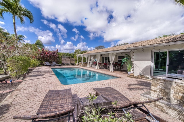 view of swimming pool featuring ceiling fan and a patio