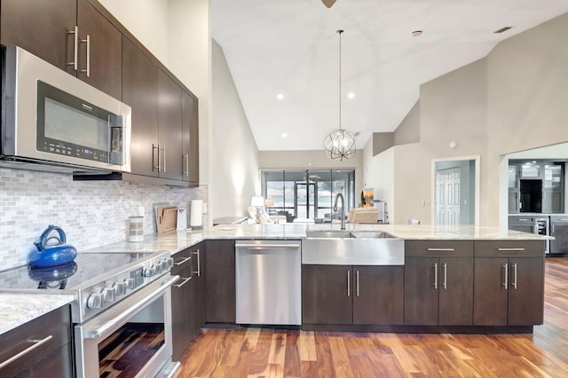 kitchen featuring pendant lighting, sink, kitchen peninsula, and appliances with stainless steel finishes