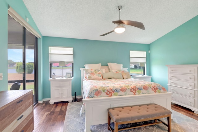 bedroom featuring access to exterior, dark hardwood / wood-style floors, a textured ceiling, and ceiling fan