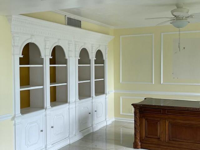 interior space with visible vents, a ceiling fan, and ornamental molding