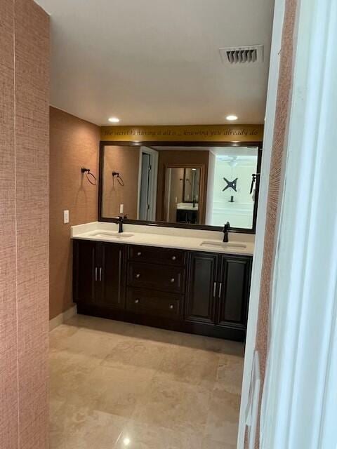 full bath featuring tile patterned flooring, visible vents, a sink, and double vanity