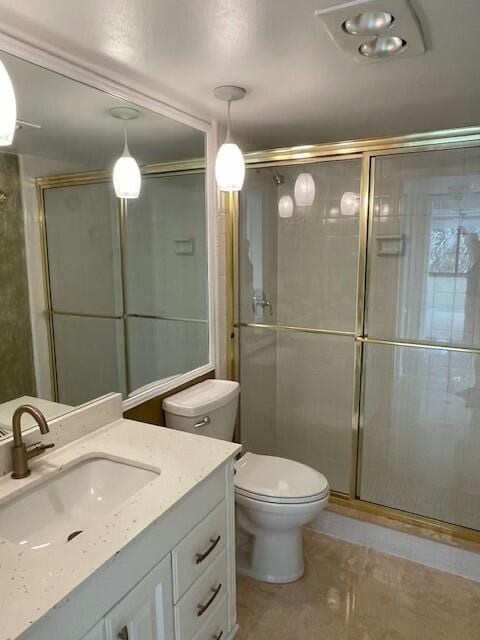 bathroom with a stall shower, vanity, and toilet