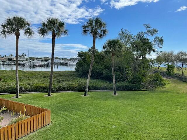 exterior space featuring a yard, a water view, and fence