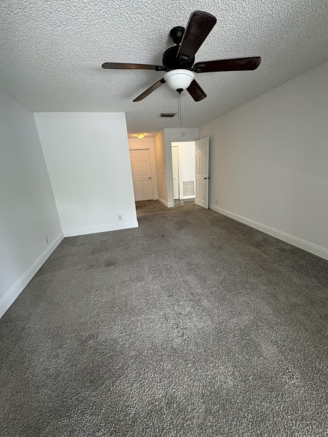 unfurnished bedroom with ceiling fan, dark carpet, and a textured ceiling