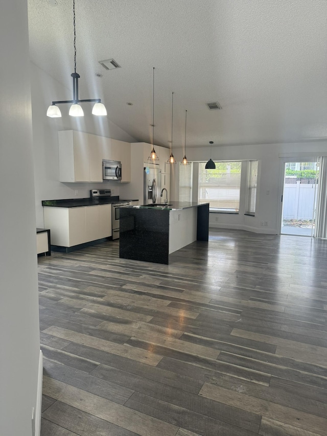 kitchen with a center island with sink, appliances with stainless steel finishes, dark hardwood / wood-style floors, pendant lighting, and white cabinets