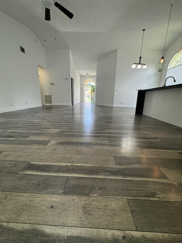 unfurnished living room featuring dark hardwood / wood-style floors, a wealth of natural light, and ceiling fan