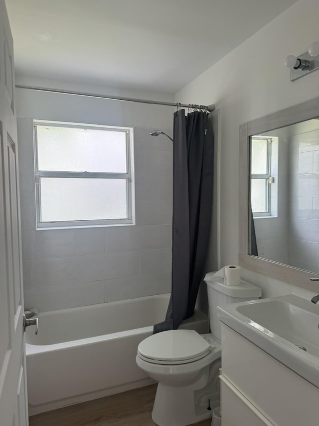 full bathroom with vanity, hardwood / wood-style flooring, toilet, and shower / bath combo with shower curtain