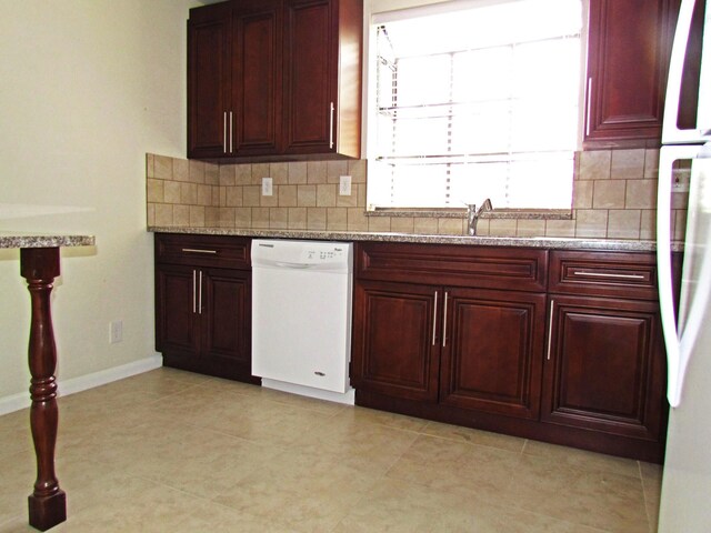 kitchen with light stone counters, dishwasher, and sink