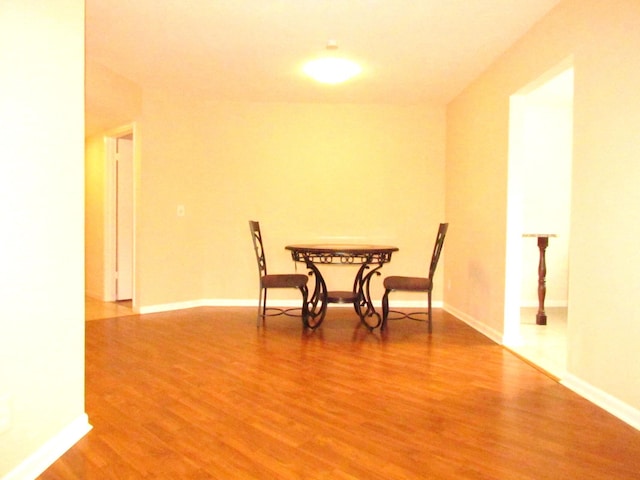 dining area featuring baseboards and light wood-style flooring