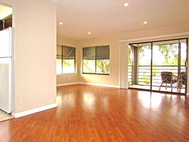 empty room with recessed lighting, baseboards, and wood finished floors