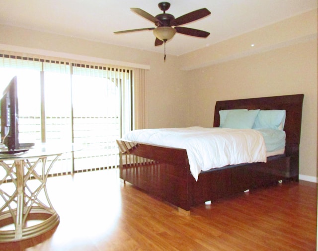 bedroom with ceiling fan, baseboards, and wood finished floors