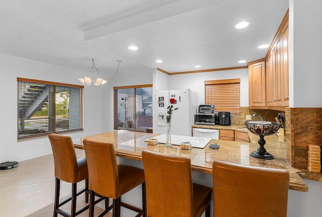 kitchen with white appliances, a breakfast bar, a peninsula, ornamental molding, and tasteful backsplash