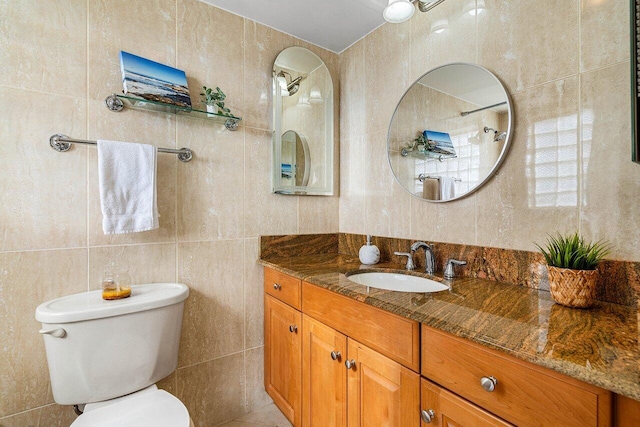 bathroom featuring toilet, tile walls, and vanity