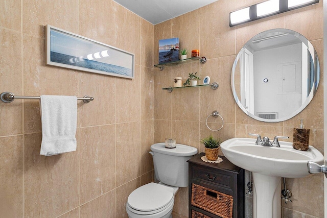 half bathroom with tile walls and toilet