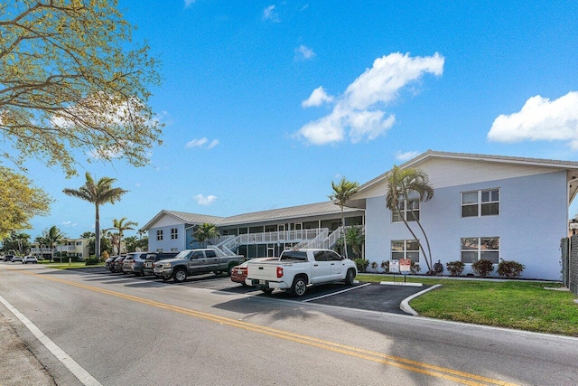 view of building exterior with a residential view and uncovered parking