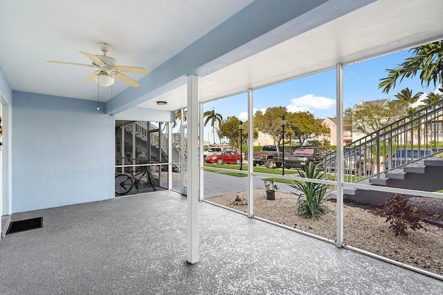 unfurnished sunroom with a ceiling fan