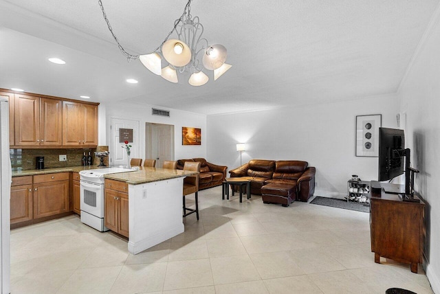 kitchen with visible vents, a breakfast bar area, electric range, a peninsula, and a notable chandelier