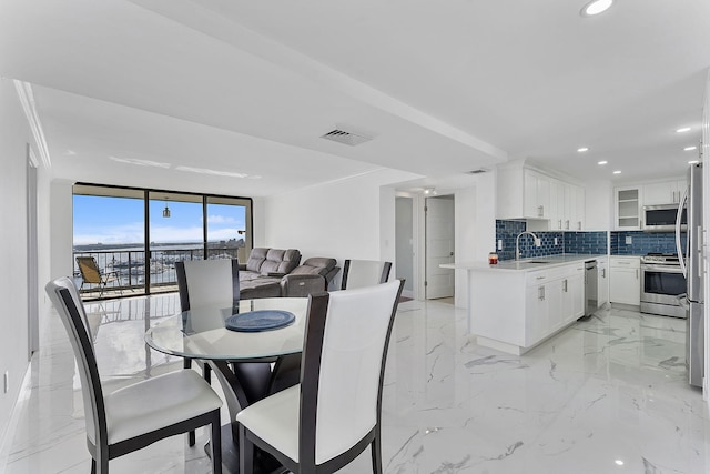 dining area with a wall of windows and sink