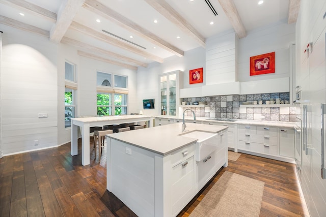 kitchen featuring white cabinetry, sink, dark hardwood / wood-style floors, and an island with sink