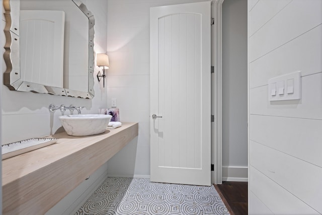 bathroom featuring sink and tile walls