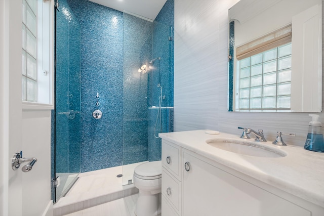 bathroom with vanity, toilet, an enclosed shower, and tile walls