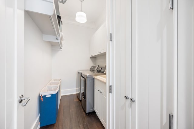 laundry area with crown molding, cabinets, dark hardwood / wood-style flooring, and washing machine and clothes dryer