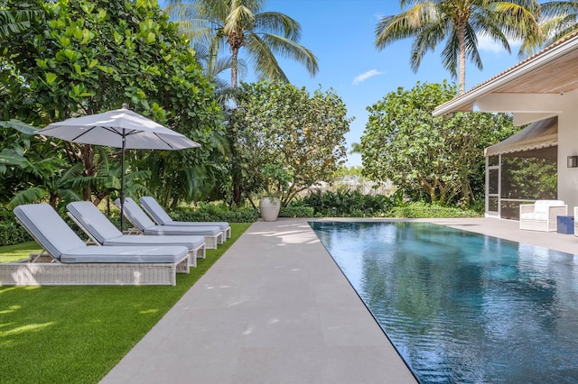 view of swimming pool featuring a patio area and a sunroom