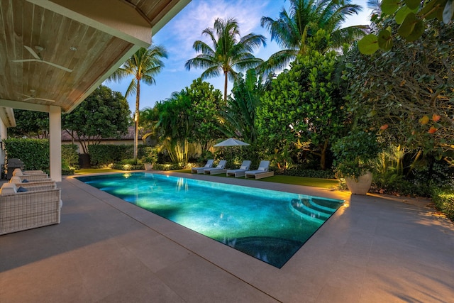 view of swimming pool featuring ceiling fan and a patio area