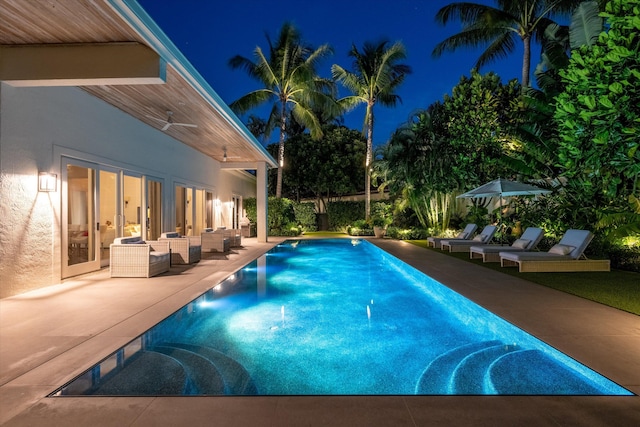 pool at twilight featuring an outdoor living space and a patio area