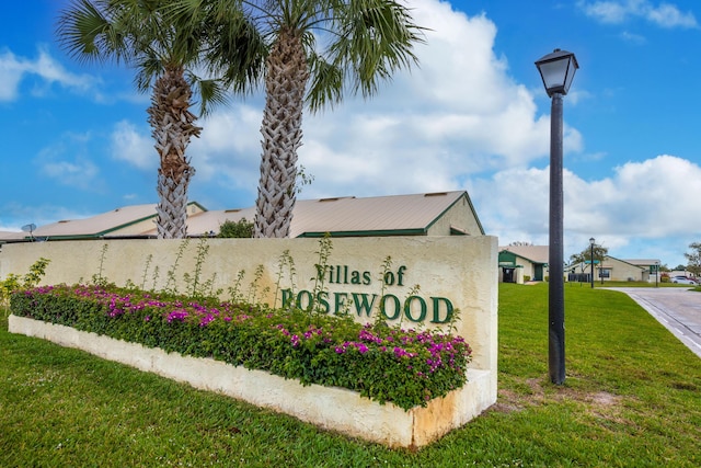 community sign featuring a lawn