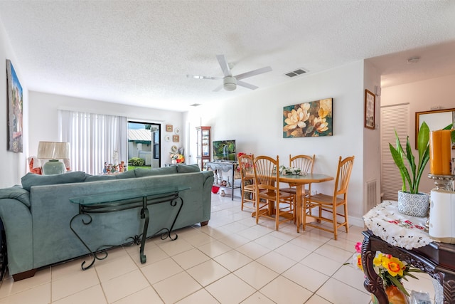 tiled living room featuring ceiling fan and a textured ceiling